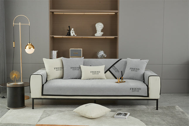 Individual sofa covers with Friend embroidery in neutral colors