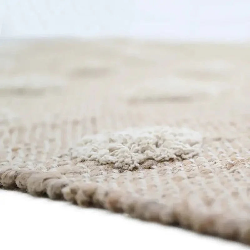 Jute and cotton rug with embossed polka dots and fringes