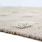 Jute and cotton rug with embossed polka dots and fringes
