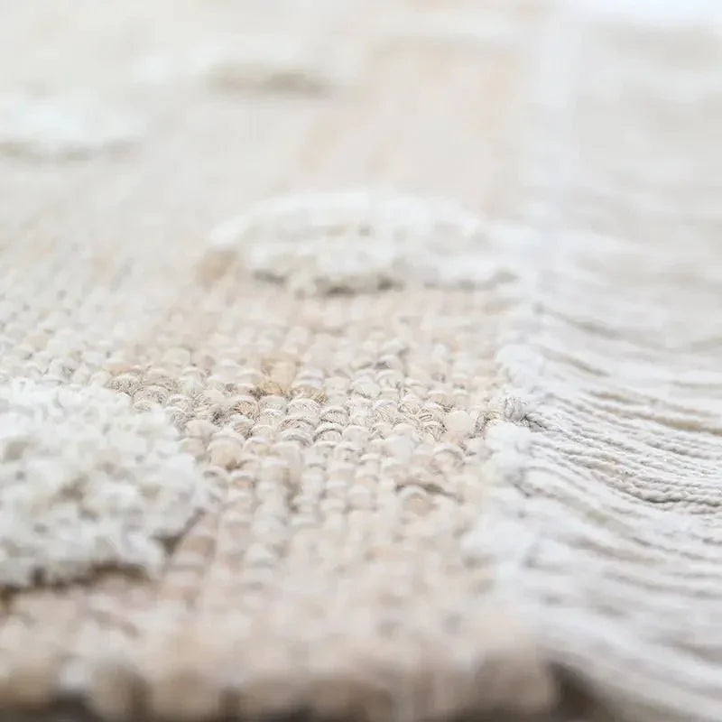Jute and cotton rug with embossed polka dots and fringes