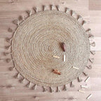 Round jute children's rug with pompoms