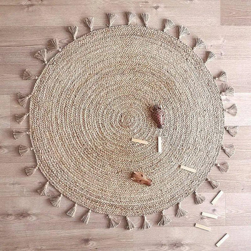 Round jute children's rug with pompoms