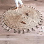 Round jute children's rug with pompoms